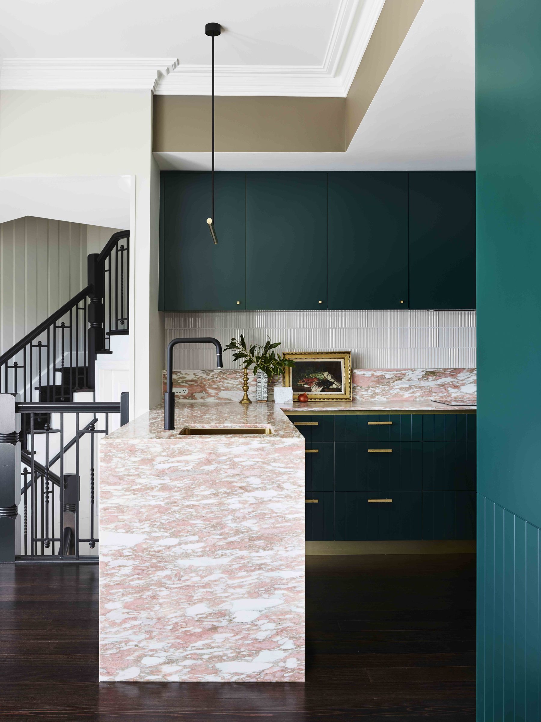 Deep green cabinetry with a marble island